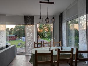 a dining room with a table and a large window at "Natur-Retreat am Bodden mit Kranichbeobachtung"-Haus kleiner Kranich in Neuendorf Hof