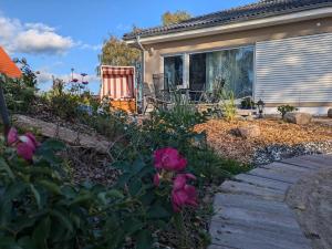 a house with a garden with flowers and a walkway at "Natur-Retreat am Bodden mit Kranichbeobachtung"-Haus kleiner Kranich in Neuendorf Hof