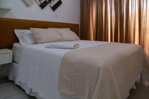 une chambre avec un lit avec des draps blancs et une fenêtre dans l'établissement Paraíso à beira-mar: Beach Living by FTT, à Mangabeira 41 autres photos