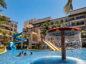 une piscine dans un complexe hôtelier avec un toboggan aquatique dans l'établissement Paraíso à beira-mar: Beach Living by FTT, à Mangabeira