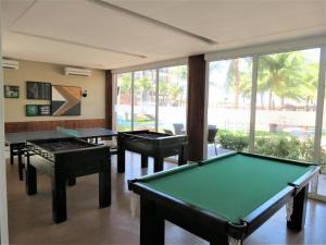 une salle de billard avec trois tables et une grande fenêtre dans l'établissement Paraíso à beira-mar: Beach Living by FTT, à Mangabeira