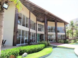 un grand bâtiment avec une piscine devant dans l'établissement Paraíso à beira-mar: Beach Living by FTT, à Mangabeira