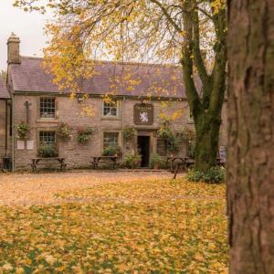 a building with leaves on the ground in front of it at Sweet Pea Cottage in Tideswell