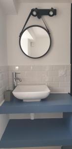 a bathroom with a white sink and a mirror at Le studio in Carhaix-Plouguer