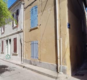 a building with blue doors on the side of it at Maison Intramuros 3 chambres 3 salles de bain - Idéal Festival in Avignon