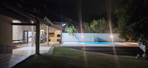 a backyard at night with a swimming pool at Chácara para Hospedagem e Festa in Taubaté