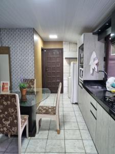 une cuisine avec un comptoir, une table et des chaises dans l'établissement Casa Da Ju, à Lauro Müller