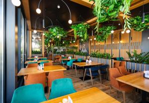 スキュネイザにあるPhoenix Medical Resortの木製のテーブルと青い椅子のあるレストラン