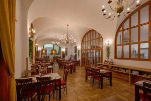 a restaurant with tables and chairs and a chandelier at Hotel Klášter Želiv in Želiv