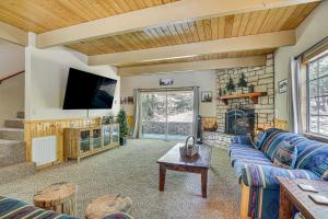 Una sala de estar con un sofá azul y una chimenea. en Big Bear Lake Cabin with Deck, Grill and Fireplace!, en Big Bear Lake