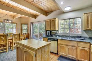 Una cocina con gabinetes de madera y un comedor. en Big Bear Lake Cabin with Deck, Grill and Fireplace!, en Big Bear Lake