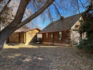 a log cabin with a tree in front of it at Cozy Canyon Cabin in Vernal