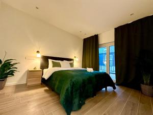 a bedroom with a large bed with a green blanket at Luxury Suites Park by Rikas Hotels in Antwerp