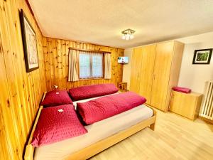 a bedroom with a bed with red pillows on it at Chalet Medi in Zermatt