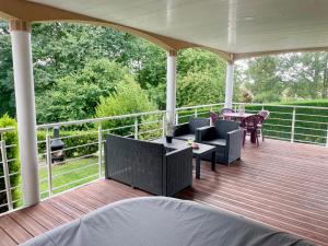a porch with a table and chairs on it at La Villa des Demoiselles in Bourg-Achard