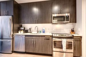 a kitchen with wooden cabinets and stainless steel appliances at Luxury Apt in the Heart of Seaport in Boston