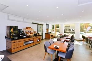 a restaurant with tables and chairs and a television at Korki's Motel in Schopfheim