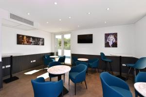 a waiting room with blue chairs and tables at Korki's Motel in Schopfheim