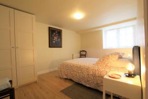 a bedroom with a bed and a table and a window at Gure gostuan in Itxassou