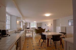 a kitchen with a table and some chairs and a kitchen with a tableablish at Gure gostuan in Itxassou +18 photos