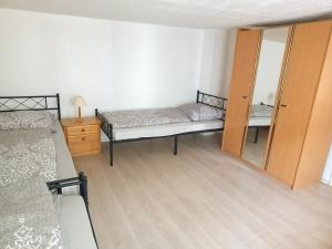 ein Schlafzimmer mit zwei Betten und einem Spiegel in der Unterkunft OCTOPUS-1 Monteurwohnung in Zentrum! 2-zkb in 1og in Hofgeismar