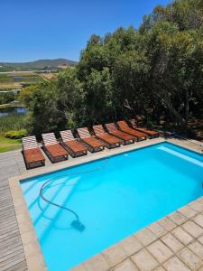 a swimming pool with lounge chairs and a swimming pool at Die Heerenhuys Guest Suites in Stellenbosch