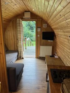 a small room with a bed and a tv in a room at Mountain Edge Resort Mega pod 6 with Hot Tub in Church Stretton