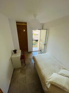 a bedroom with a bed and a table and a window at Apartamento Tomillo in Rincón de la Victoria
