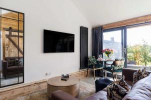 a living room with a couch and a table at Romantic Countryside Lodge with Hot Tub in North Mundham