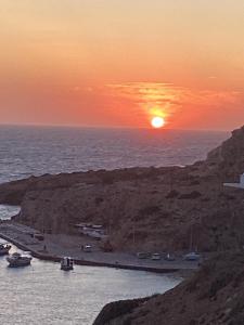 a sunset over a body of water with boats at Almyra Boutique Suites with Private Pool -Finiki in Foinikion