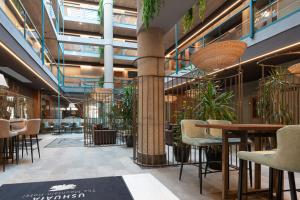 a lobby with tables and chairs and plants at Ushuaia, The Mountain Hotel in Arinsal