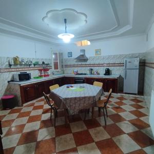 a kitchen with a table with chairs and a refrigerator at Alger avec vue imprenable sur la Baie d'Alger Piscine Balcon Terrasse in El Mouradia