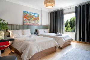 um quarto com duas camas e uma janela em The Crimson Sun Charm em Cairo