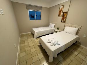 um quarto com duas camas e uma janela em Apto 3 quartos grande a 50m do Mar AH113 em Tambaú mais 27 fotografias