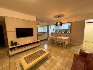 uma sala de estar com televisão e uma sala de jantar em Apto 3 quartos grande a 50m do Mar AH113 em Tambaú