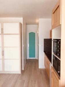 Una cocina vacía con un microondas y una puerta. en Merveilleux Studio Face La Mer, en Royan