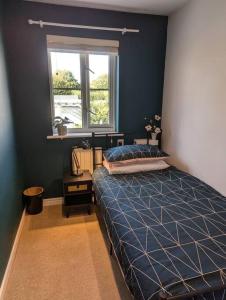 a blue bedroom with a bed and a window at Modern 3B Eastbourne Retreat: Tranquil & Cozy Stay in Eastbourne +19 photos