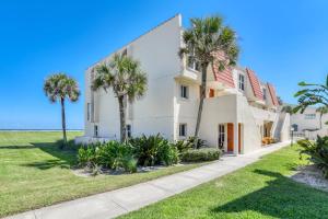 a white house with palm trees in front of it at Pier Point 57 in St. Augustine