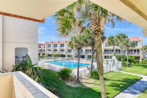 an apartment with a swimming pool and palm trees at Pier Point 57 in St. Augustine
