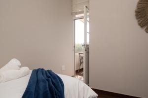 a bedroom with a bed with a blue blanket on it at 903 Umdloti Resorts in Umdloti