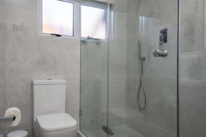 a bathroom with a toilet and a glass shower at 903 Umdloti Resorts in Umdloti +24 photos