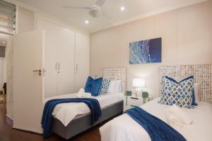two beds in a bedroom with blue and white at 903 Umdloti Resorts in Umdloti