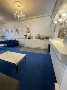 a living room with a blue carpet and a table at The New ATLAS HOTEL in Blackpool
