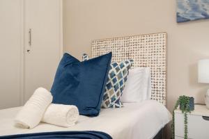 a bedroom with blue and white pillows on a bed at 903 Umdloti Resorts in Umdloti