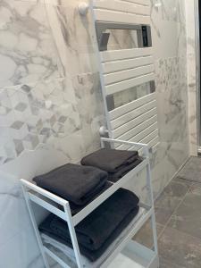 a towel rack with four towels in a bathroom at La cachette de Chanteloup in Chanteloup-en-Brie