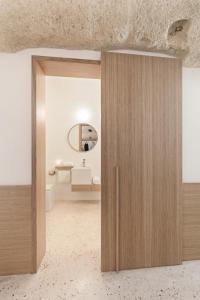 a wooden door in a room with a bathroom at La Dimora Di Metello in Matera