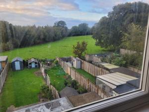 a view from a window of a garden with a field at Little Willows in Handcross
