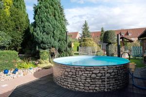 a pool in a yard with a stone tub at Ferienwohnung Fred in Warenshof