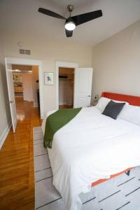 a bedroom with a large white bed with a ceiling fan at The Getaway in DT Northfield! in Northfield