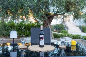 a bottle of wine sitting on a table with glasses at Ikia Iviskos in Igoumenitsa